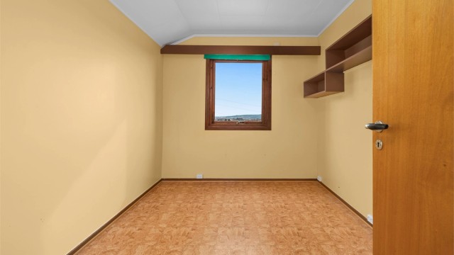 Et lyst og trivelig soverom, ideelt som barnerom eller kontor.