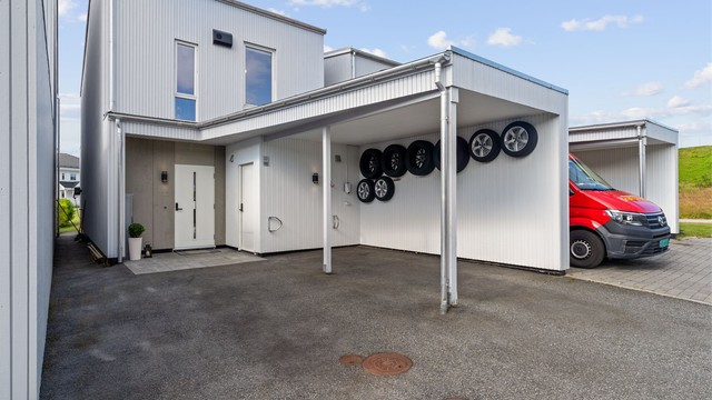 Stort gårdsrom og carport med elbil lader.