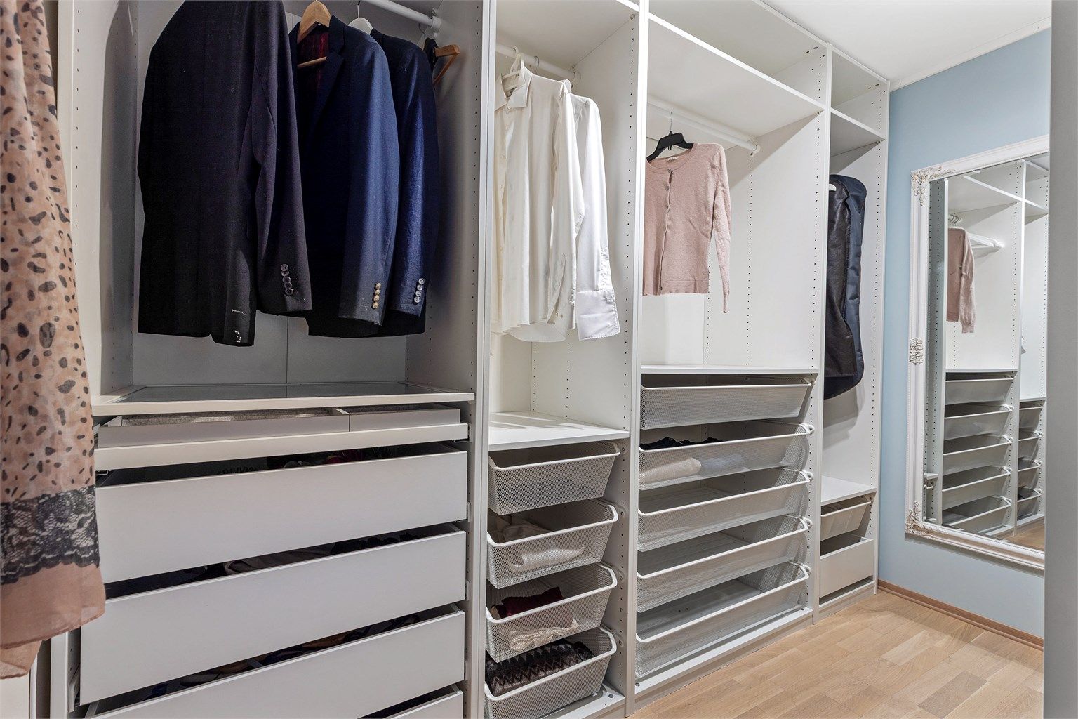 Praktisk walk-in-closet innredet med skuffer og oppheng.