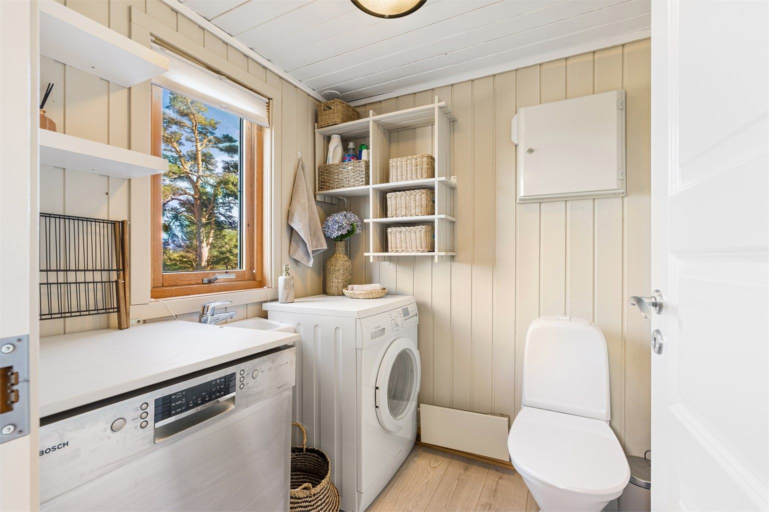 Praktisk separat toalettrom på 3 kvm med gode lagringsmuligheter. Her er det etablert oppvaskmaskin og vaskemaskin.