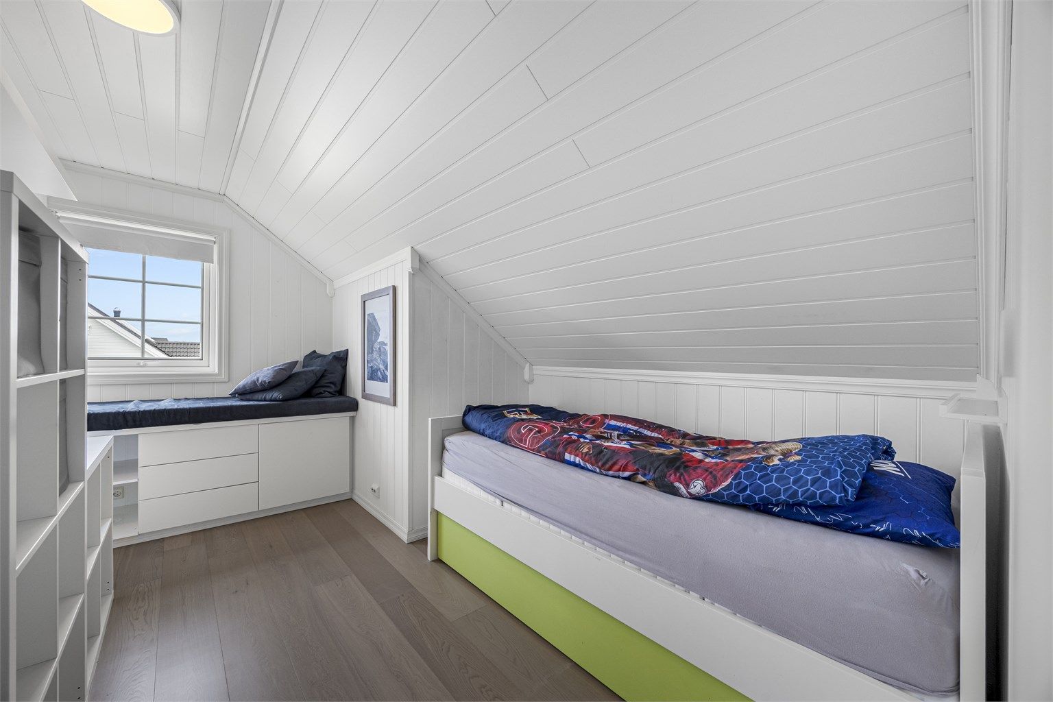 Et av de tre soverommene i loftsetasjen, med smart utnyttelse av plassen under skråtaket.