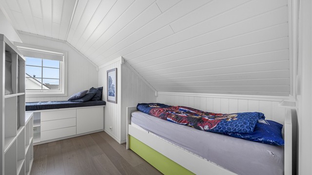 Et av de tre soverommene i loftsetasjen, med smart utnyttelse av plassen under skråtaket.