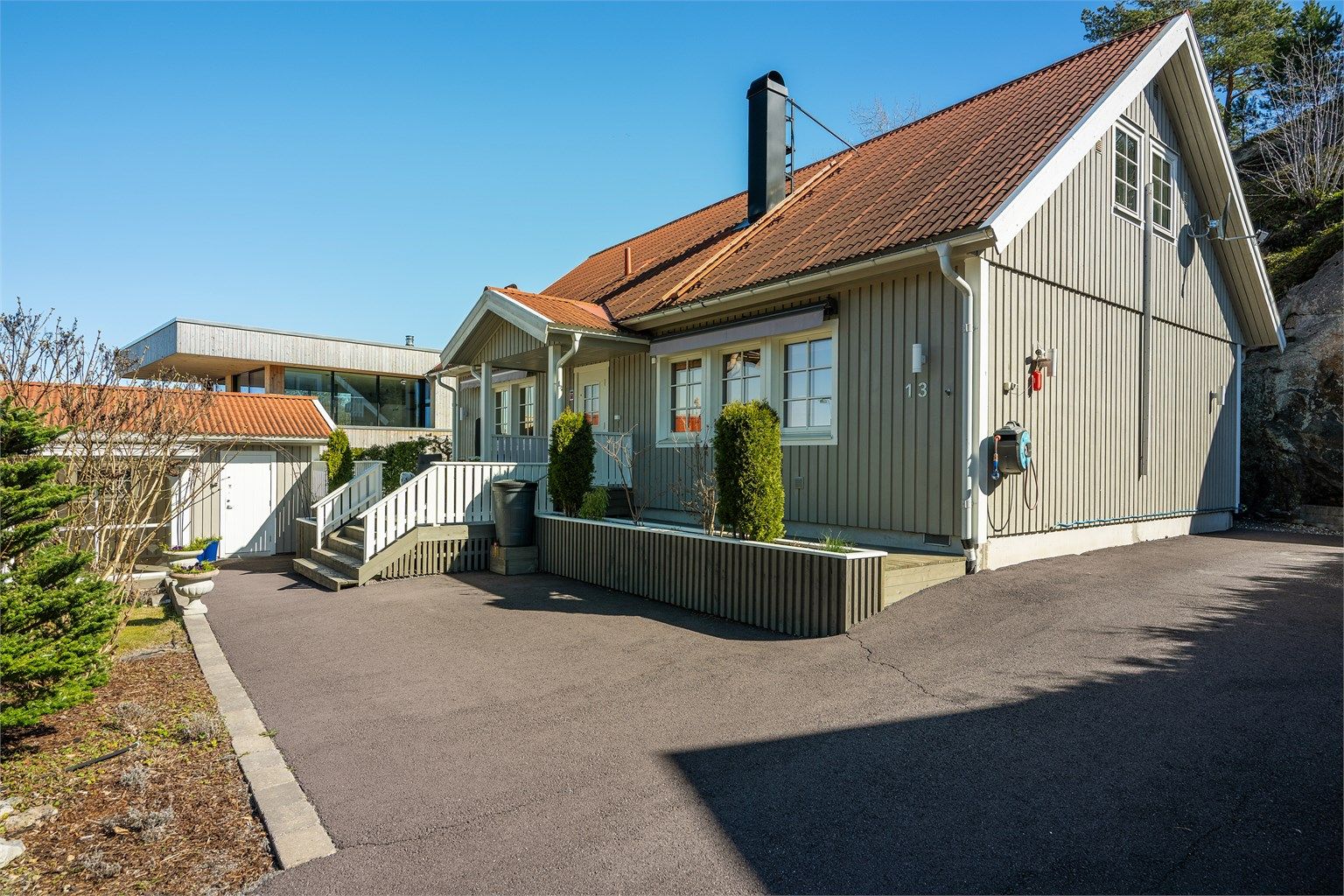 Boligen har stående bordkledning og tak tekket med steinbelagte stålplater.
