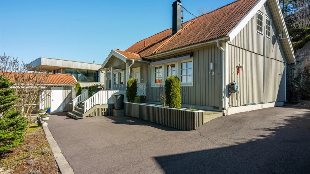Boligen har stående bordkledning og tak tekket med steinbelagte stålplater.