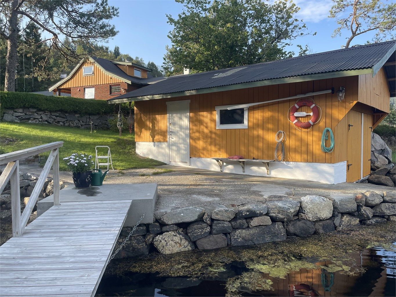 Naust ved sjøen med flytebrytte