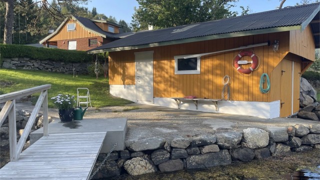 Naust ved sjøen med flytebrytte