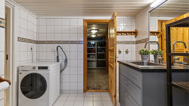 Praktisk bad i kjelleren med gulvvarme og opplegg for vaskemaskin.