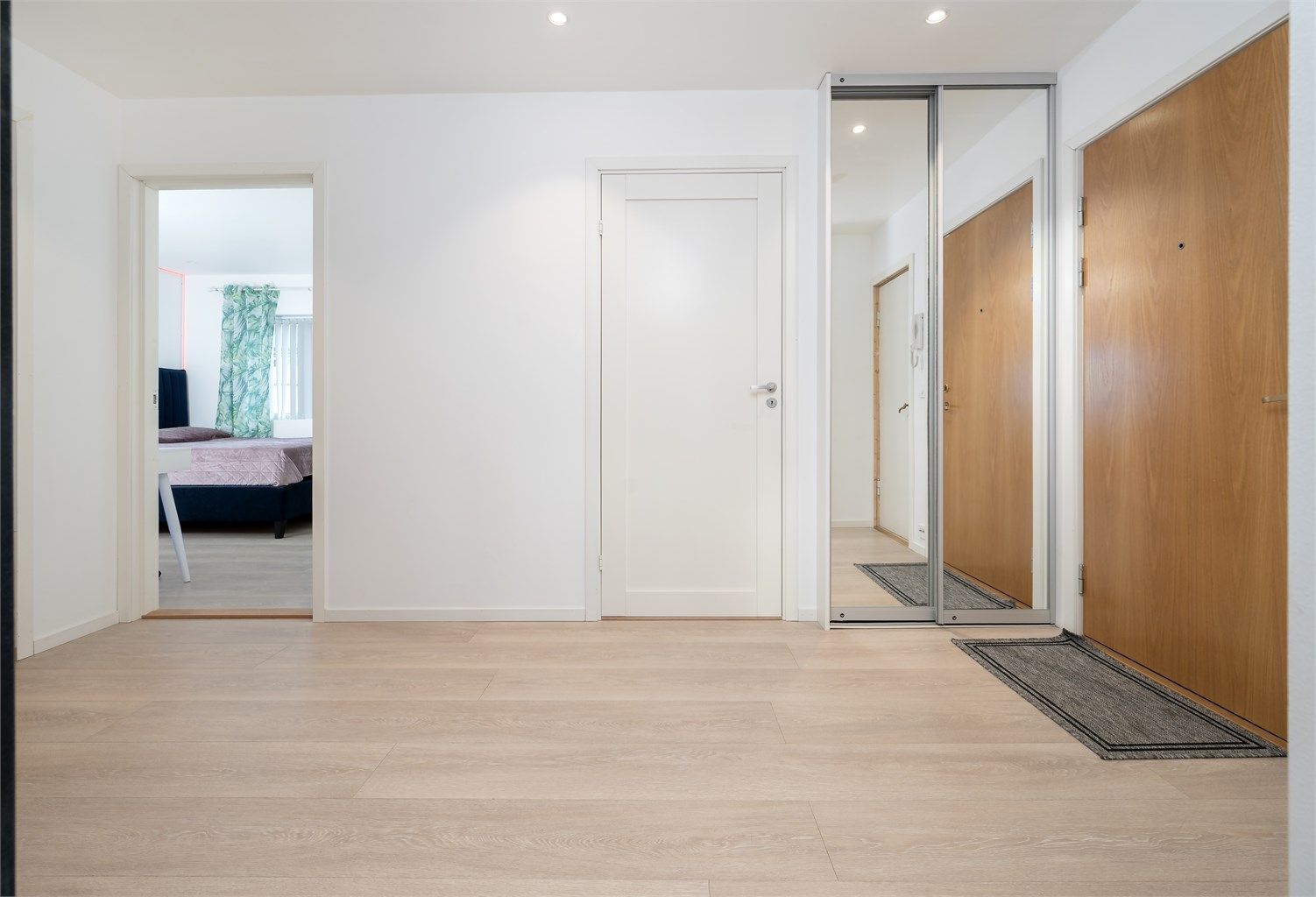 Gangen har en praktisk skyvedørsgarderobe med speilfronter for oppbevaring av yttertøy.