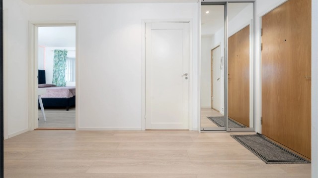 Gangen har en praktisk skyvedørsgarderobe med speilfronter for oppbevaring av yttertøy.