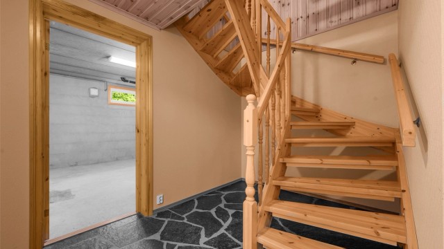 Trapperommet i kjelleren har skifergulv og leder inn til de øvrige rommene.