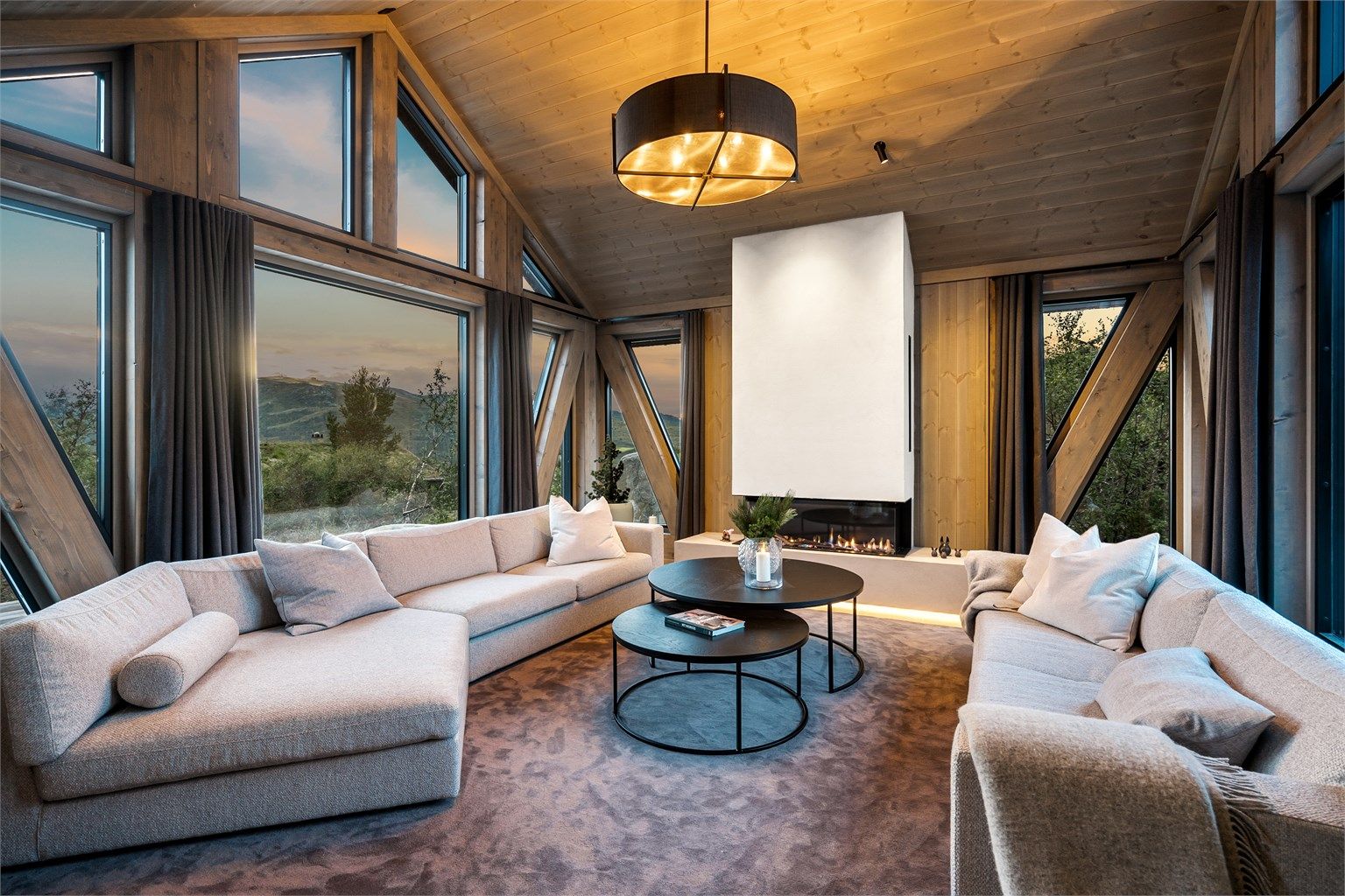 Romslig stue i nordenden av hytta, gode vindusflater og flott gasspeis. 