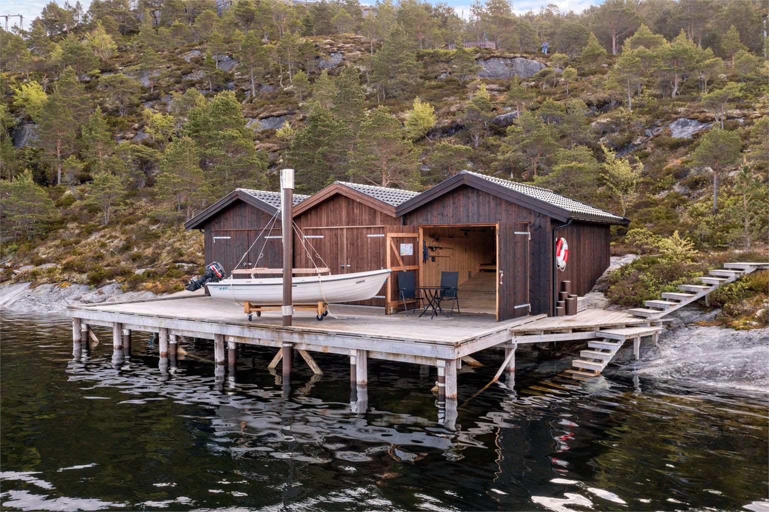 Eiendommen inkluderer innholdsrik hytte, uthus og naust med felles brygge. 