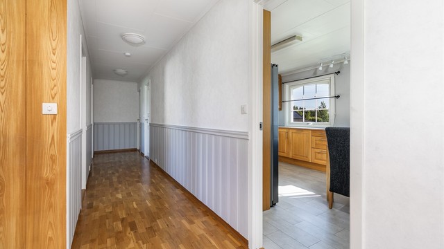 Soverommene er tilbaketrukne og samlet omkring gangen innenfor spisestuen og kjøkkenet, i praktisk nærhet av badet.