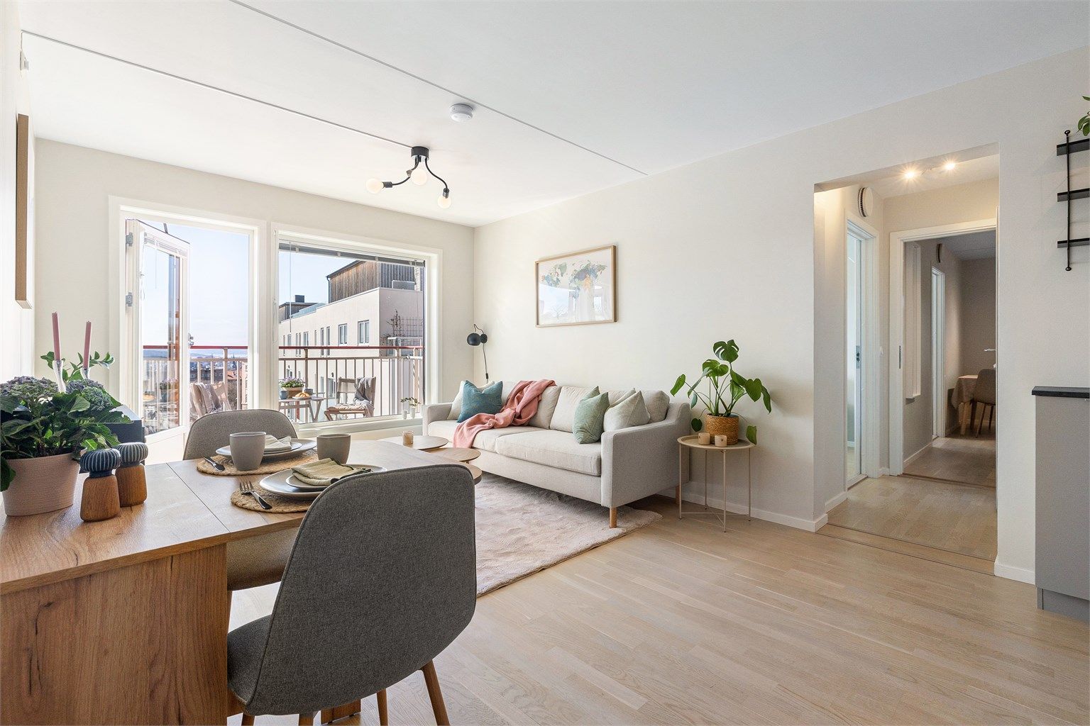 Stuen har god plass til både sofagruppe og spisebord, med direkte utgang til balkongen.