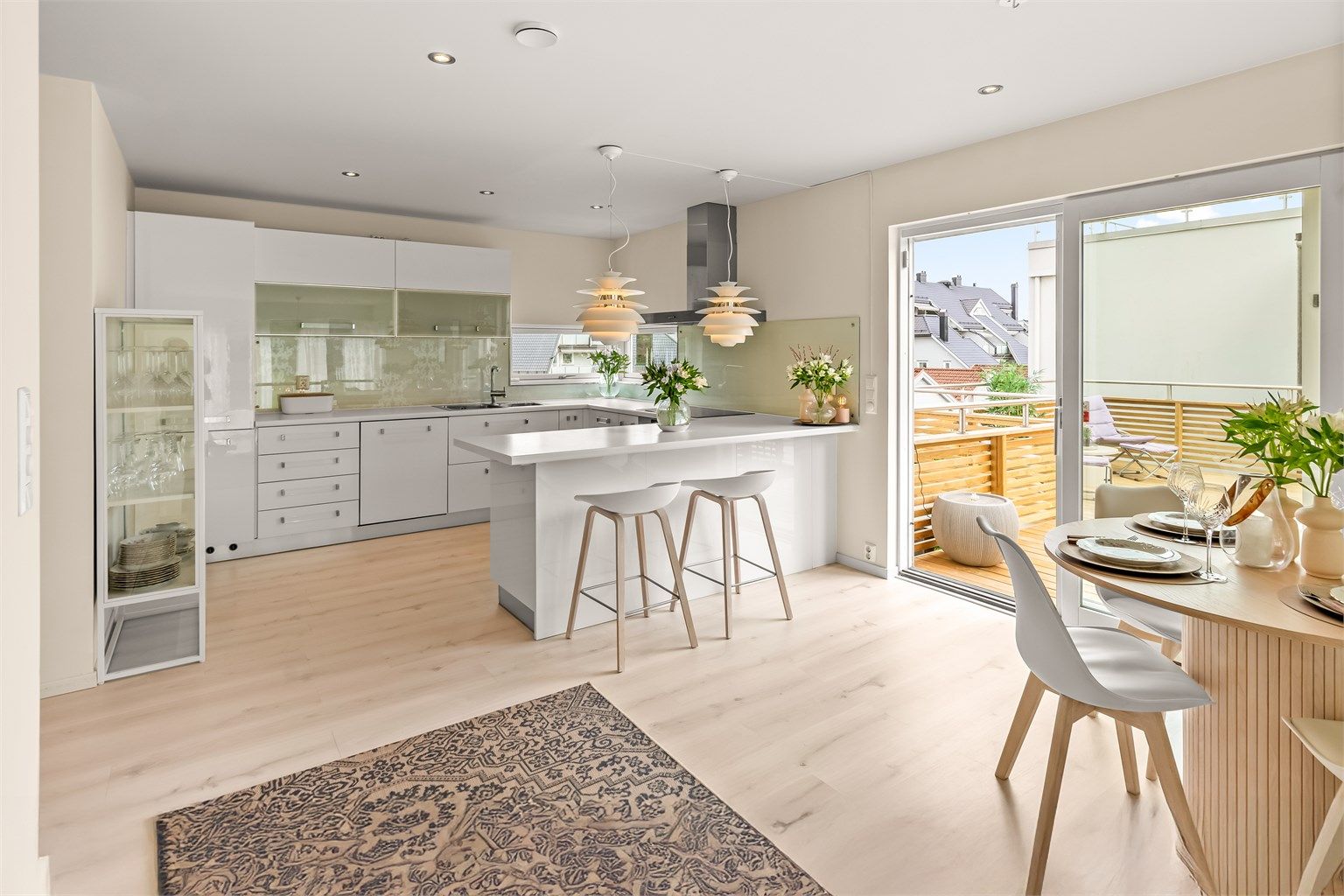 Lyst og moderne innredet kjøkken med rikelig skapplass og benkeplass 