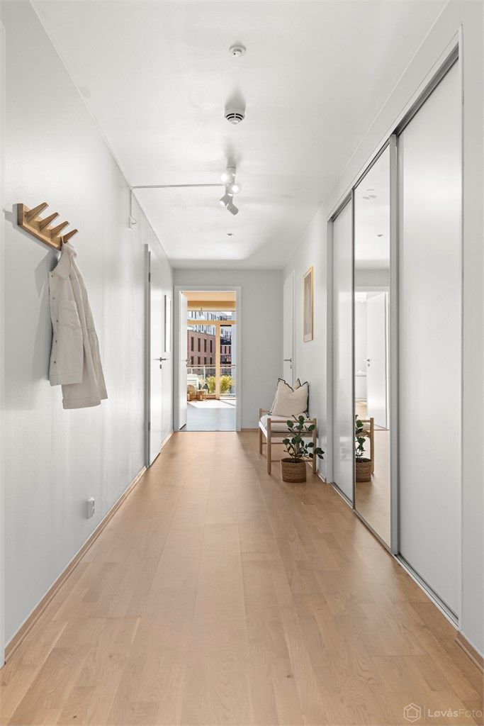 I tilknytning til entréen ligger et separat omkledningsrom med skyvedører. Dette gir ekstra garderobeplass og fungerer som et lite walk-in closet. 