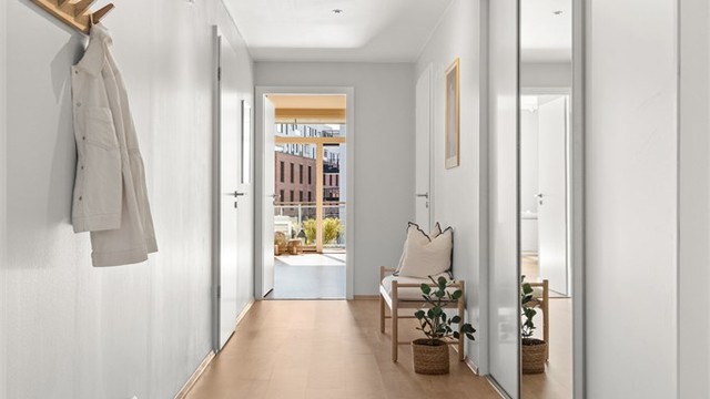 I tilknytning til entréen ligger et separat omkledningsrom med skyvedører. Dette gir ekstra garderobeplass og fungerer som et lite walk-in closet.