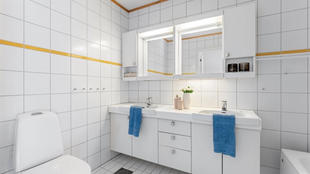 Baderom fra byggeår med flislagt gulv med gulvvarme og dobbel servant.