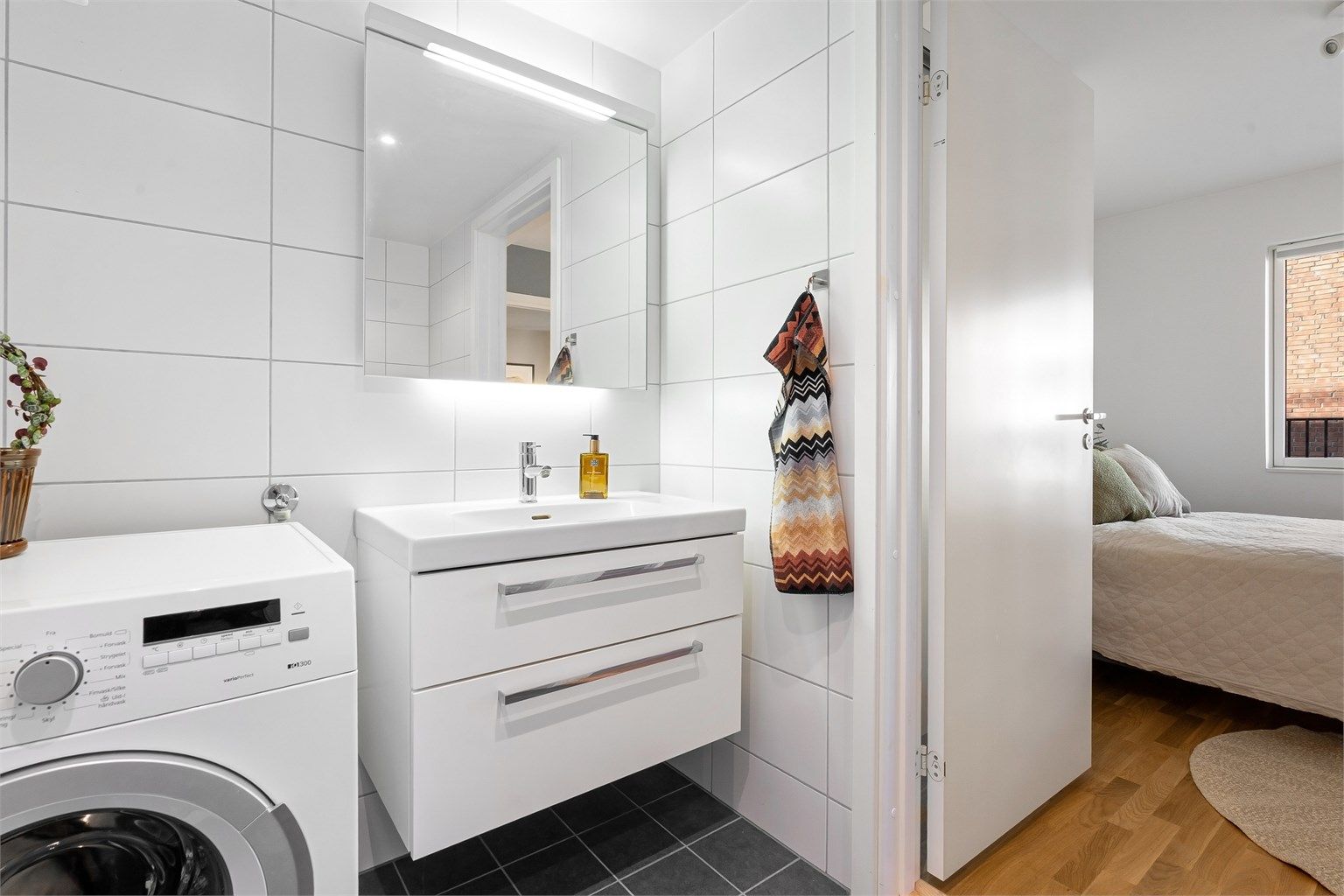 Baderomsinnredningen har skuffer for oppbevaring, og speil med integrert overlys.