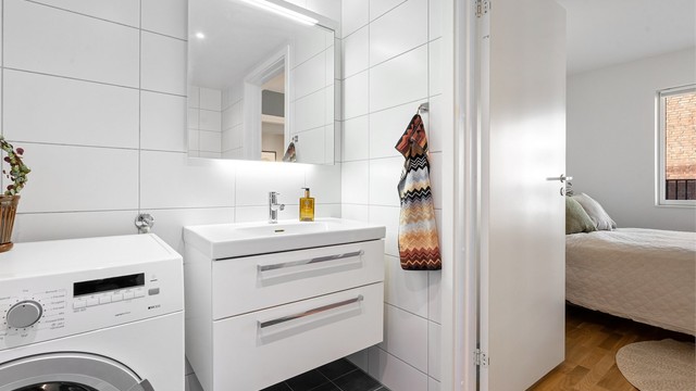 Baderomsinnredningen har skuffer for oppbevaring, og speil med integrert overlys.