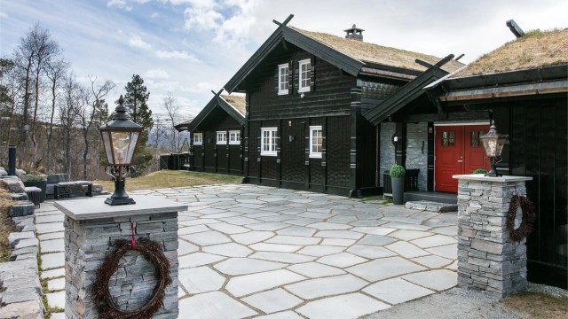Portstolper i naturstein rammer inn innkjørselen til eiendommen.