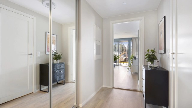 I entréen er det plass til oppbevaring. En dør med glassfelt leder videre inn til stue og kjøkken.