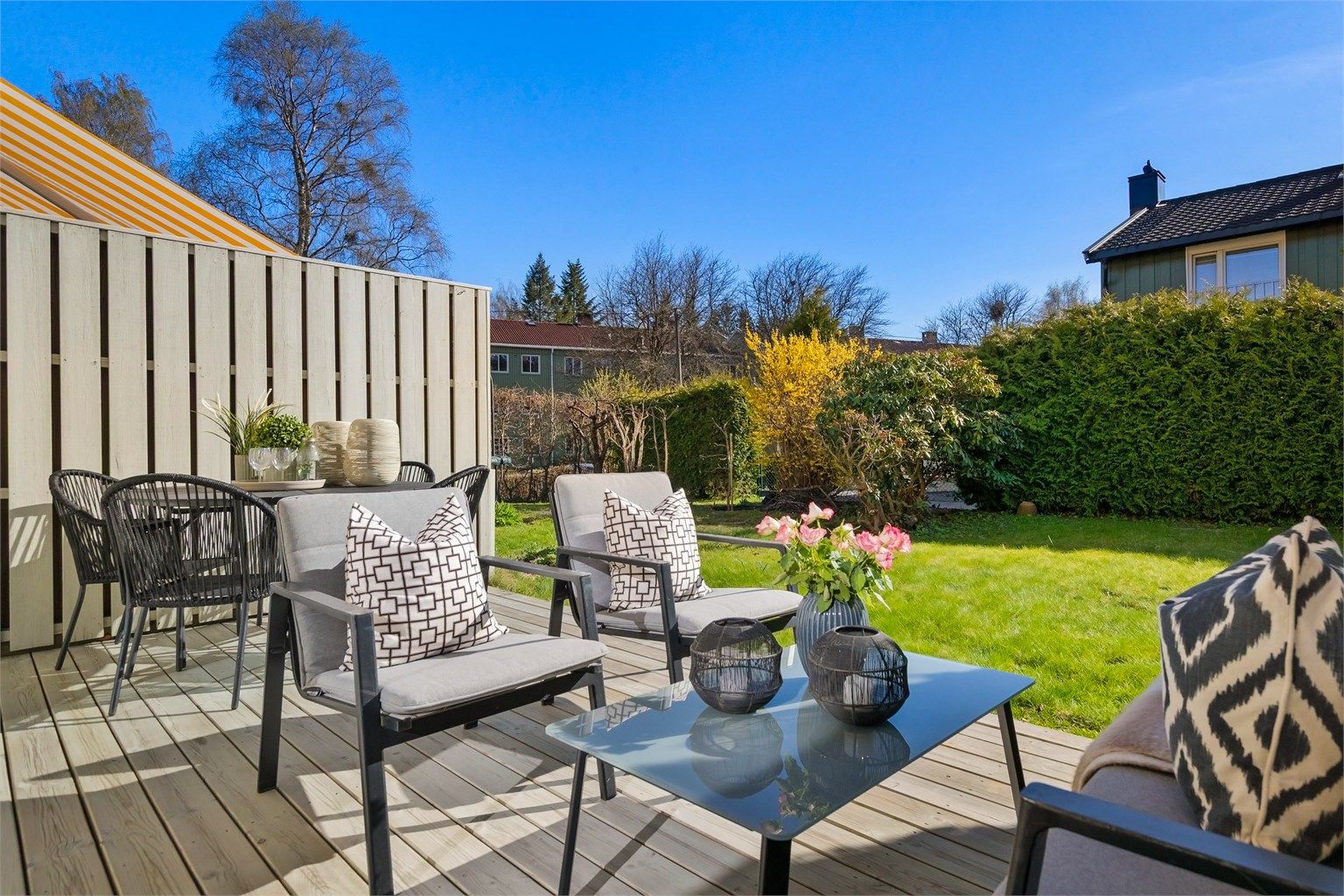 Uteplassen er skjermet med hekk og gjerde, noe som skaper en privat og usjenert atmosfære.