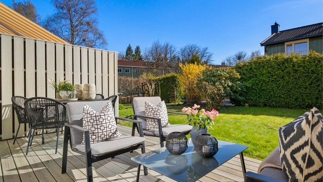 Uteplassen er skjermet med hekk og gjerde, noe som skaper en privat og usjenert atmosfære.