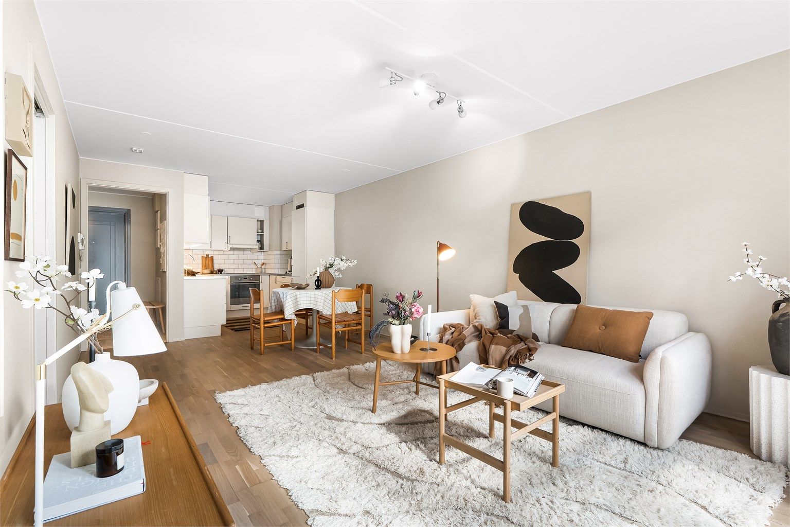  Leiligheten har en lys og trivelig stue med sosial planløsning med åpen kjøkkenløsning. Foto: Oh Shots.