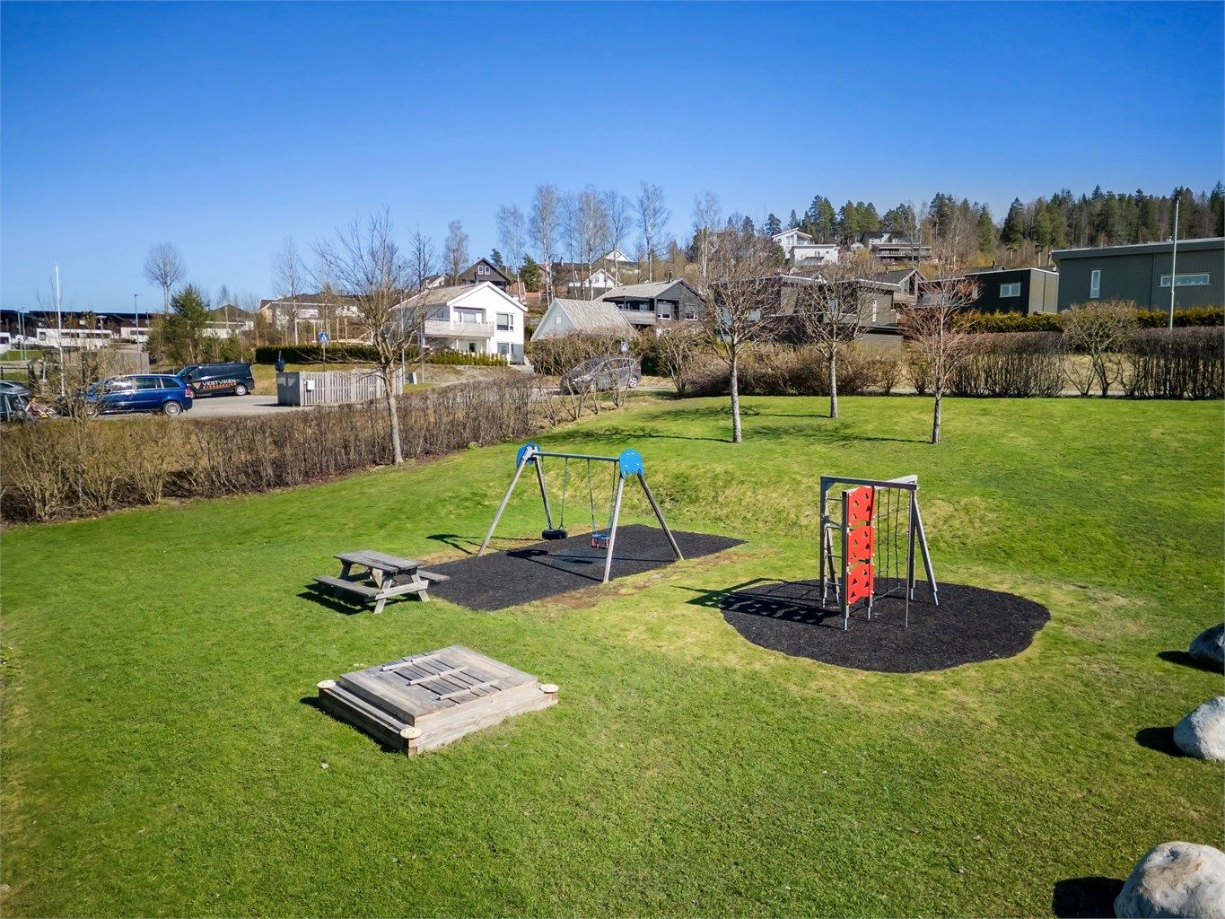 Tomten utgjør grøntarealer, adkomstveier, parkeringsområder, carportanlegg, lekeplass m.m. 
