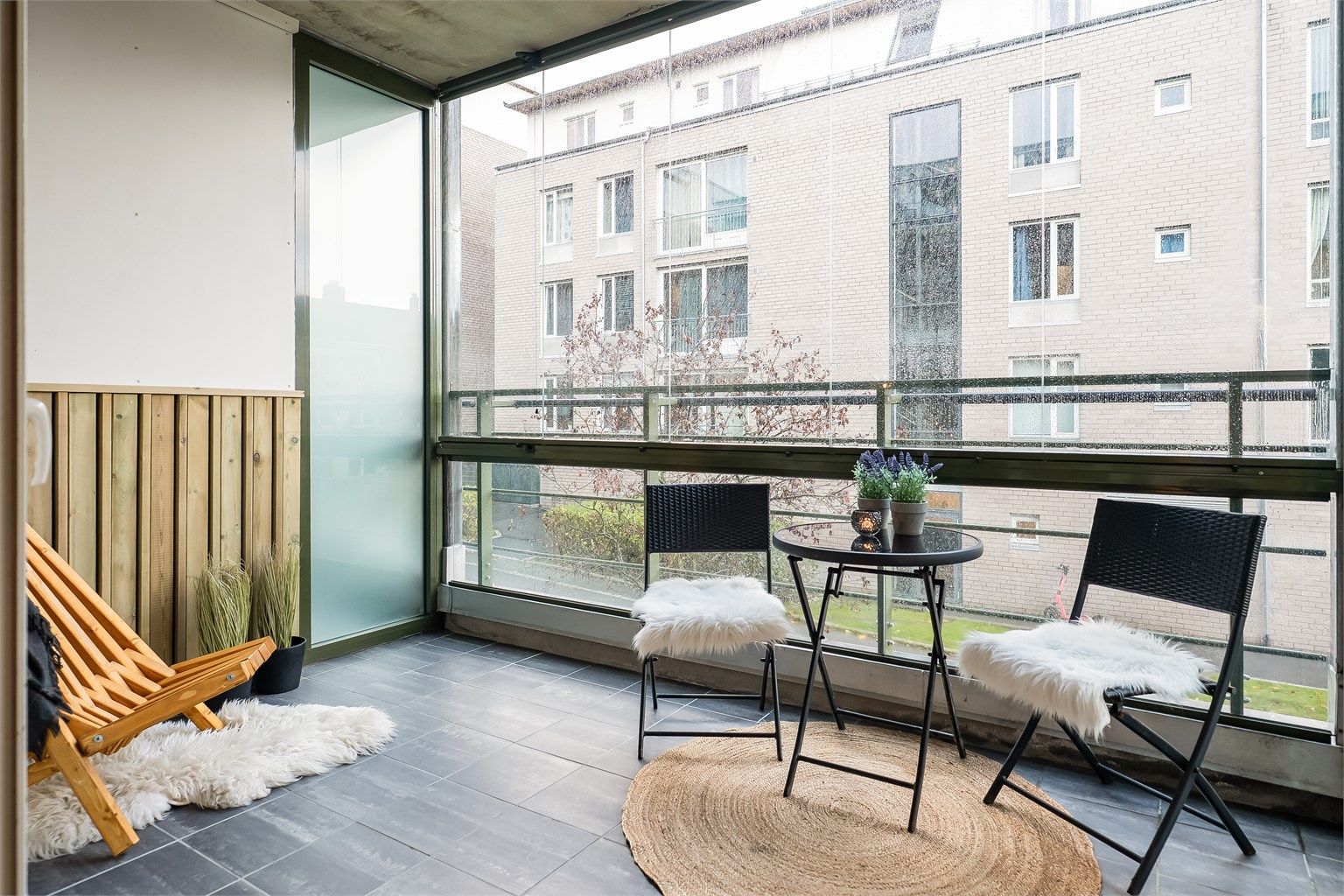 Romslig innglasset balkong med flisbelagt gulv og nye panelbord på vegg