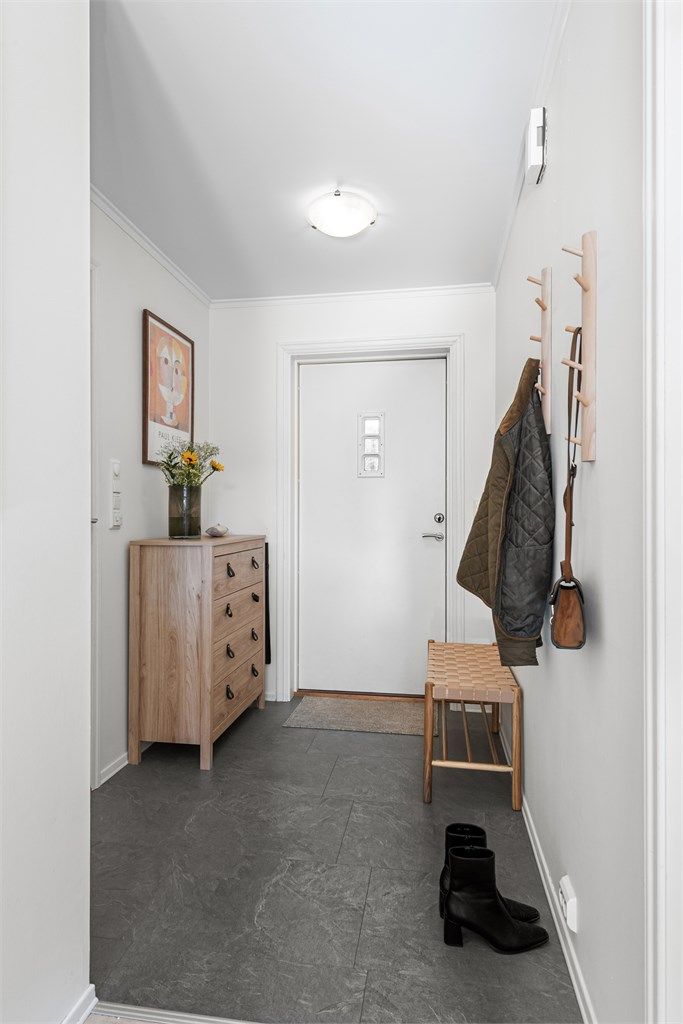 Entré med praktiske laminatfliser på gulvet og plass til klesoppheng.