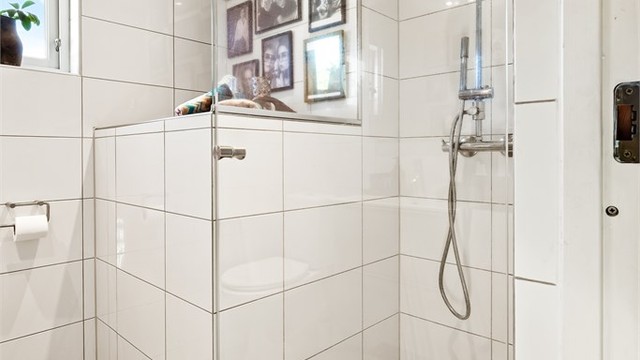 Badet har dusjnisje med dusjdør av glass og regnfallsdusj.