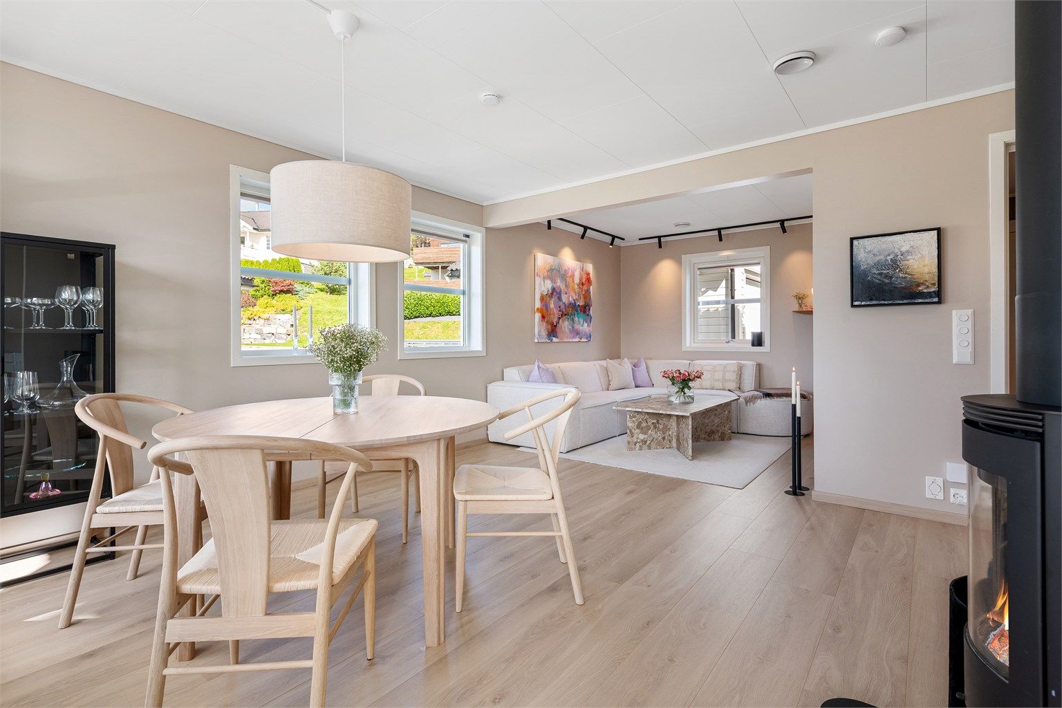 Åpen stue og kjøkkenløsning med gulvvarme, flott belysning og tilpasset solskjerming