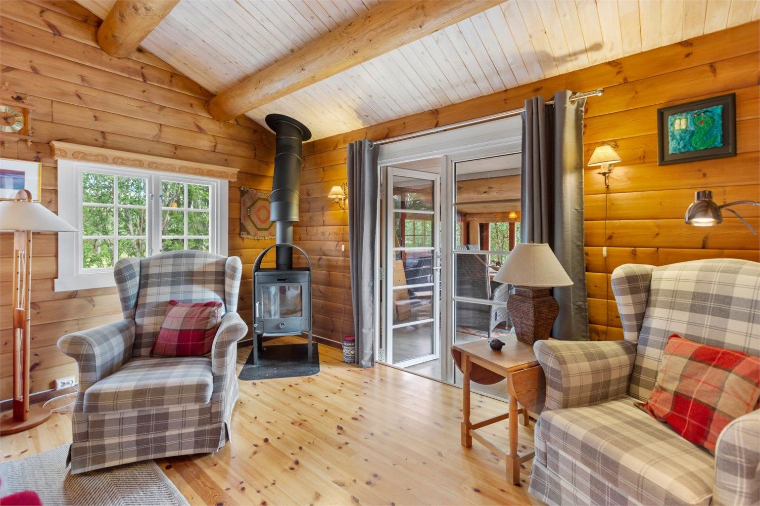 Krogsveen Sunnmøre v/Harald Osdal har gleden av å presentere en unik og innholdsrik fritidsbolig - bildet tatt innenfra stuen, med de doble dørene slått åpne ut mot den møblerte utestuen 
Foto: Jarle Osen