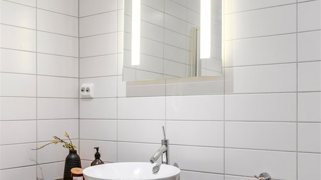 Servantinnredning med skuffer, og speil med integrert belysning og stikkontakt.