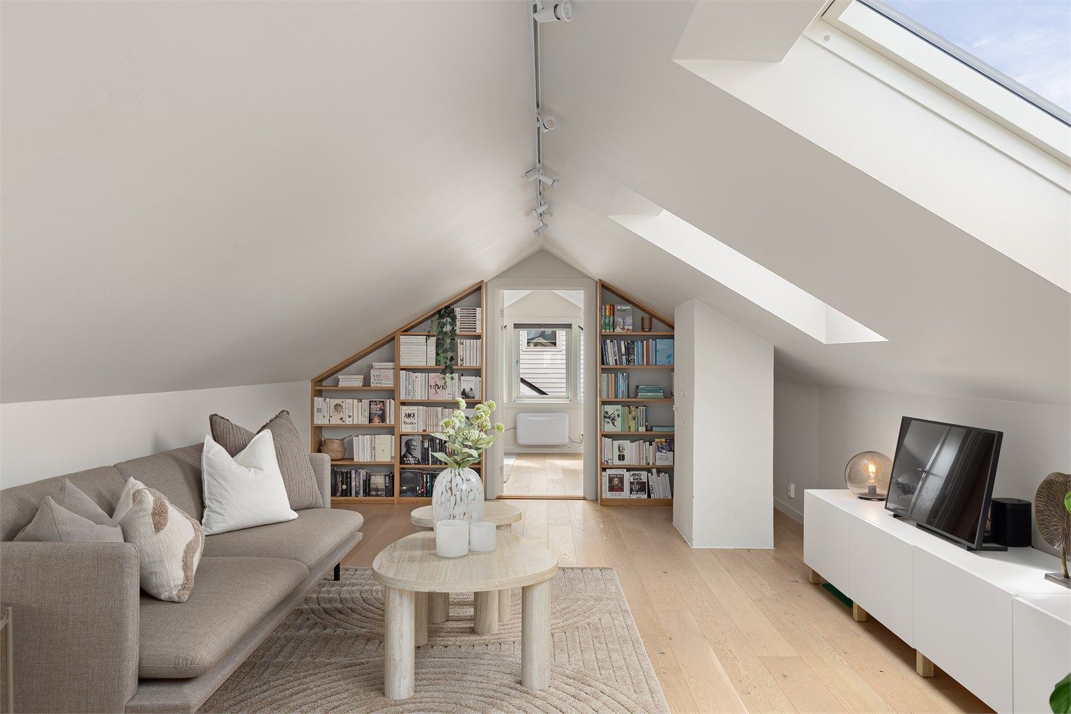 Lys og fin loftstue med plass til sittegruppe, tv-benk + tv, samt lesestol og/eller barneleker. Plassbygde bokhyller på vegg inn mot soverom. 