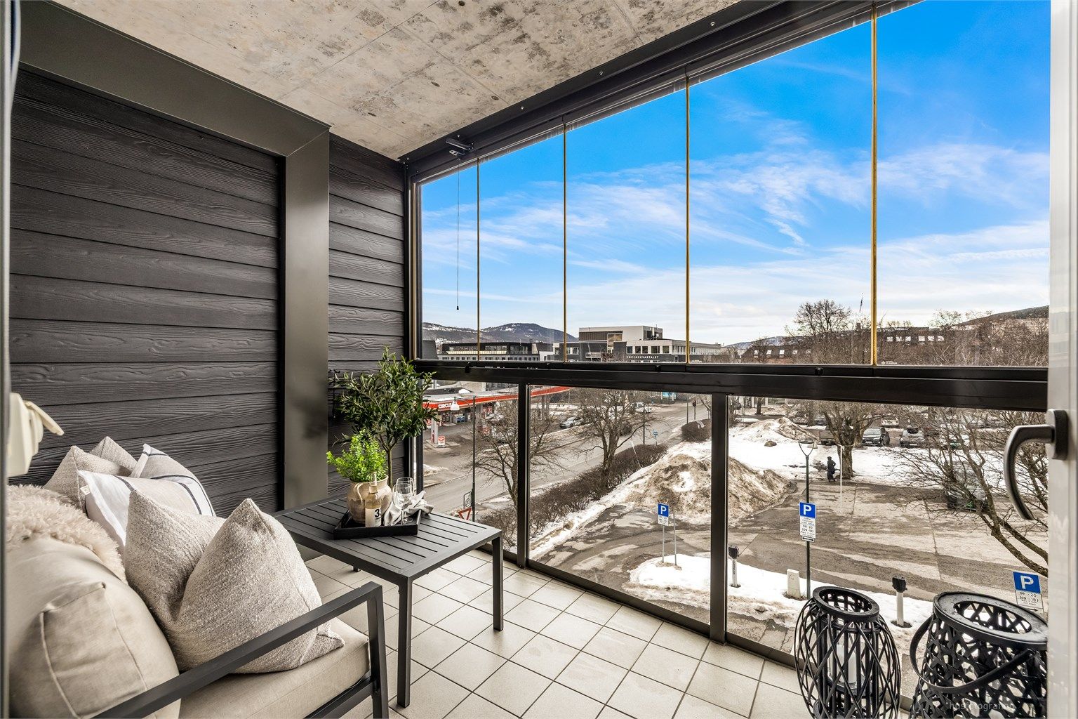 Innglasset vestvendt balkong på ca. 7 kvm med skyvbare glassfelt og flislagt gulv.