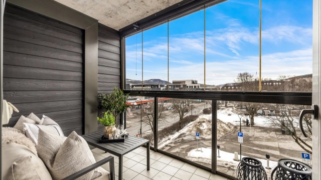 Innglasset vestvendt balkong på ca. 7 kvm med skyvbare glassfelt og flislagt gulv.