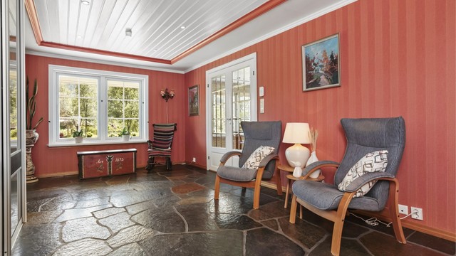 Romslig hall med gode lagringsmuligheter for sko og yttertøy i skyvedørsgarderobe.