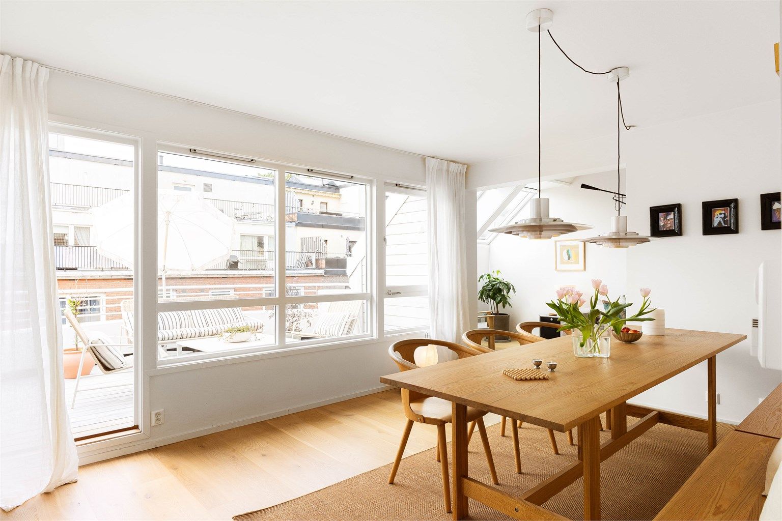 Store vindusflater langs hele veggen fyller det langstrakte rommet med dagslys fra morgen til kveld, og fra spisestuen går man rett ut på takterrassen.