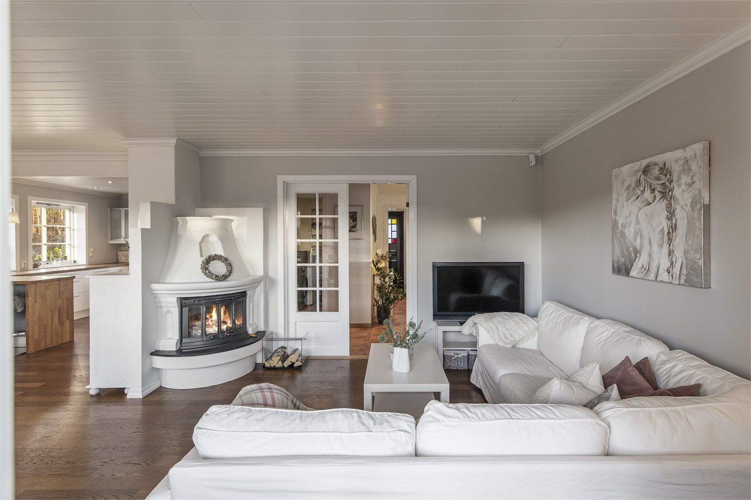 Pent innredet tv-stue i hovedetasje med utgang til terrasse og hage 