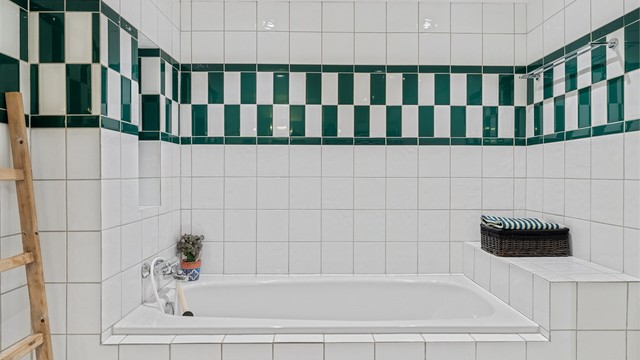 Innbygget badekar omkranset av flislagte flater.