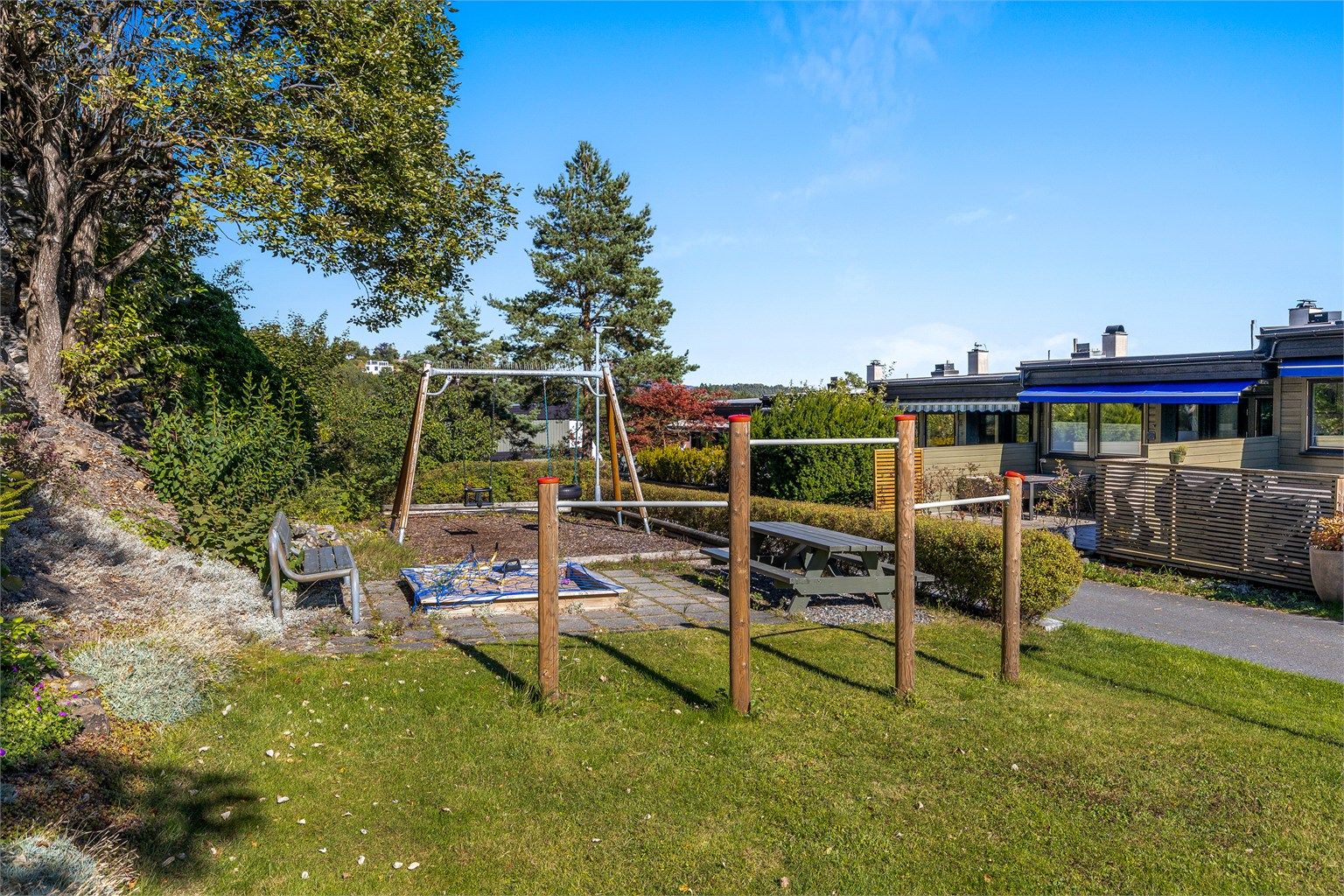 Fellesarealet bak rekkehusene er opparbeidet med lekeplass og sittebenker.