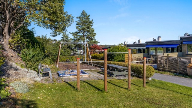 Fellesarealet bak rekkehusene er opparbeidet med lekeplass og sittebenker.