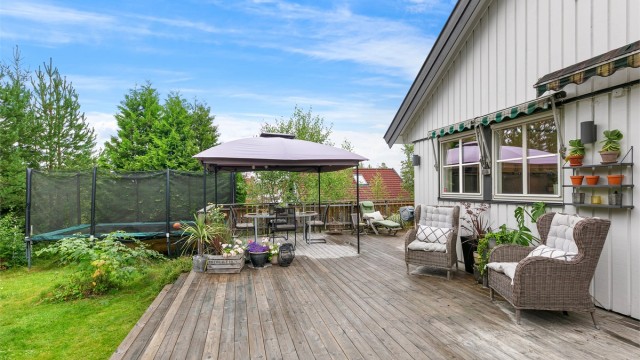 Solrik og skjermet hage med stor terrasse – her er det god plass til både spisegruppe og sofagruppe