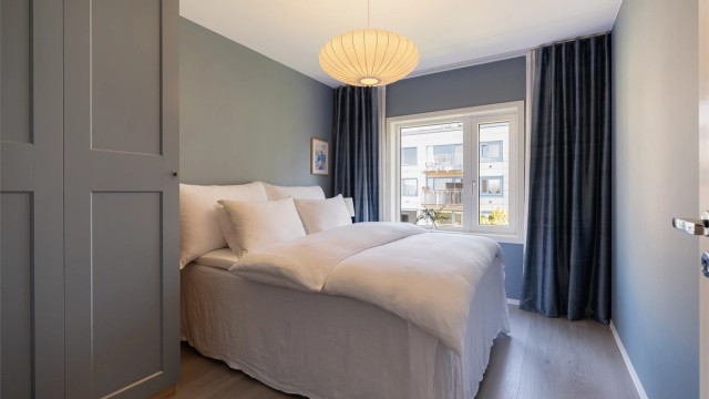 Svalt og romslig soverom i hoveddel med plass til dobbeltseng, nattbord og stort garderobeskap.