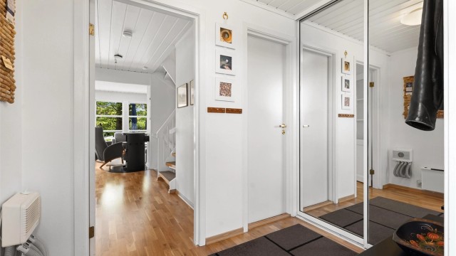Fra entreen åpner boligen seg opp mot stuen og kjøkkenet.