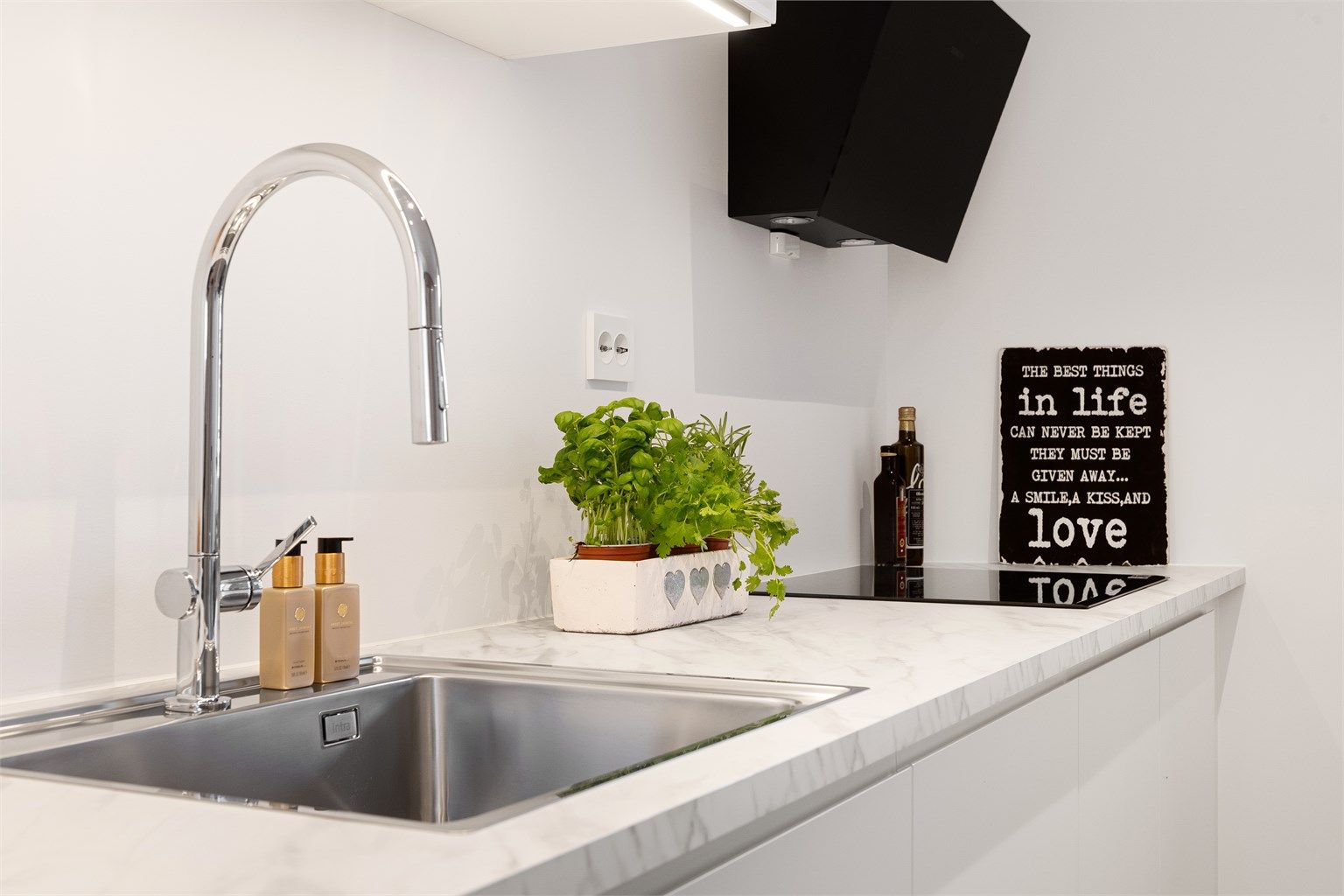 Detaljer som underlimt vask og moderne platetopp understreker den gjennomførte stilen