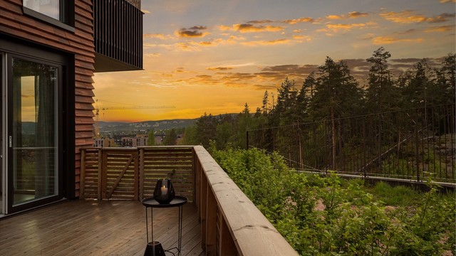 Store skyvedører i glass skaper en sømløs overgang mellom ute- og innerom.